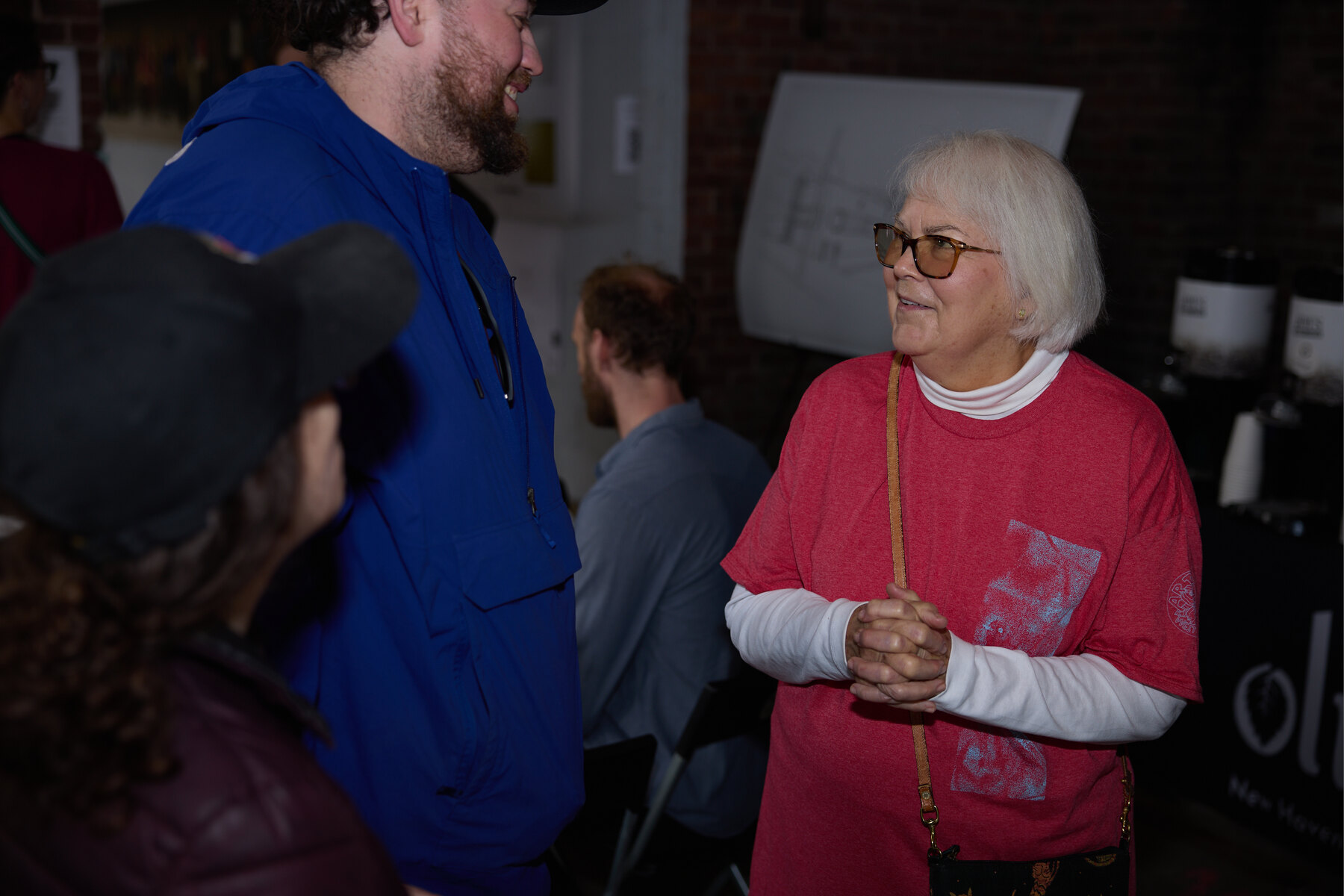 Visitors gathered around a table during the Bagels in the Black Box open house